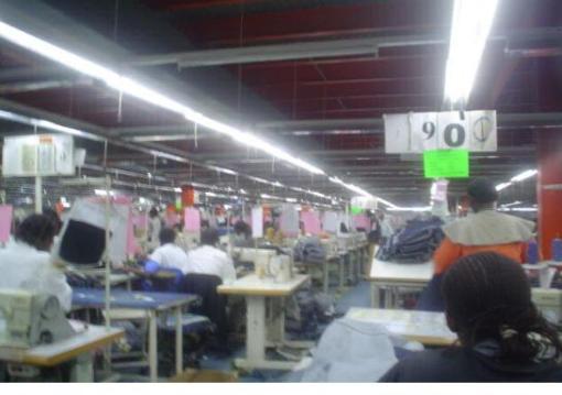 Ruaraka Export Processing Zone, EPZ, near Nairobi.  This is the fifth or sixth hour of production.  The 900 indicates the total number of jeans produced at that time.  But the daily target is indicated on the green papers, which is between 1200 and 1500.  If the EPZ workers do not meet this target by 5pm, they will have to stay until they finish.  They will not be paid overtime because they were supposed to reach the target in 8 hours.  (picture from Pamoja Tunaweza slideshow)